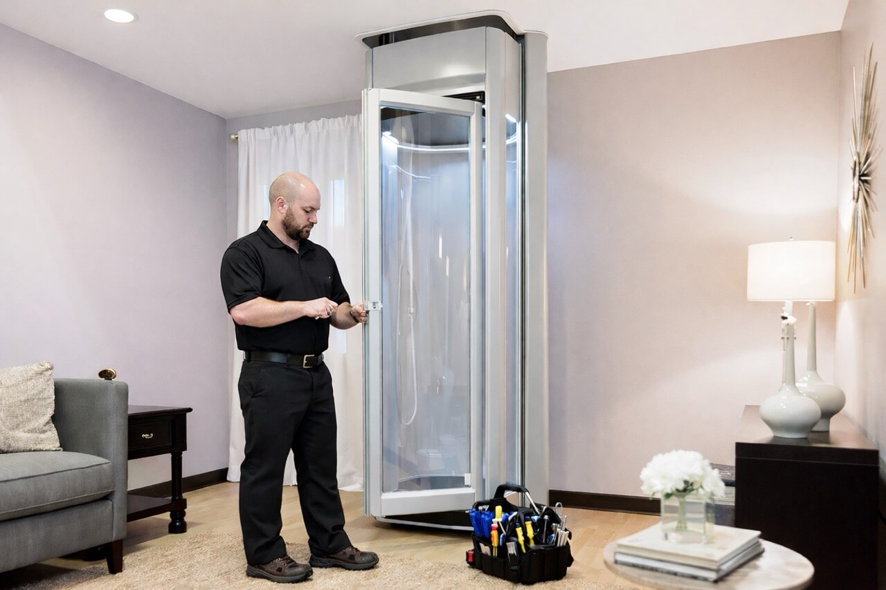 Home lift servicing carried out by a trained engineer inspecting a through-floor lift during routine maintenance.